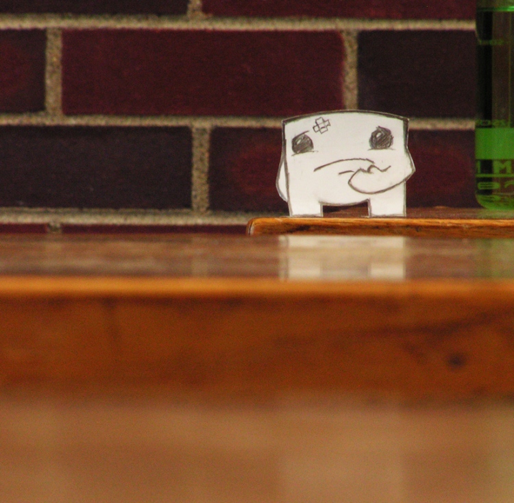 A photo of a paper cutout of Meat Boy from Super Meat Boy contemplating his jumps